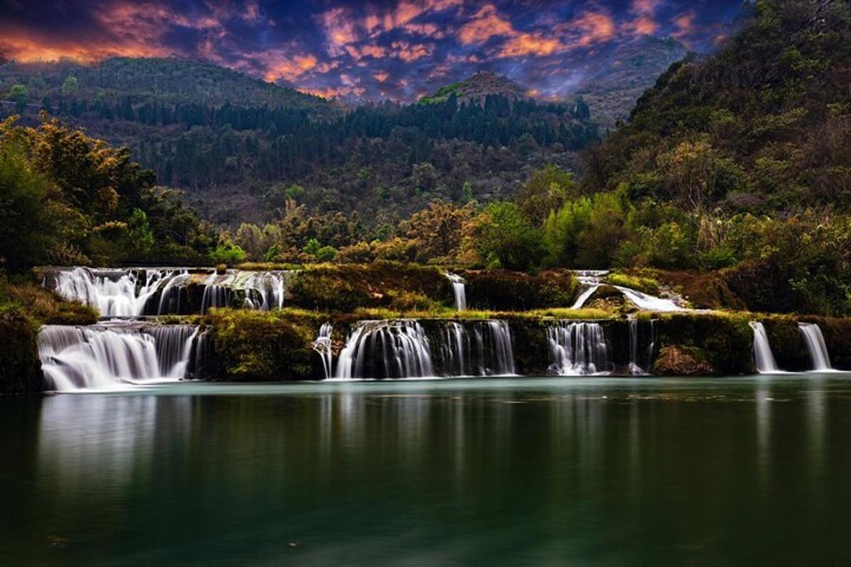 a group of waterfalls in the middle of a lake