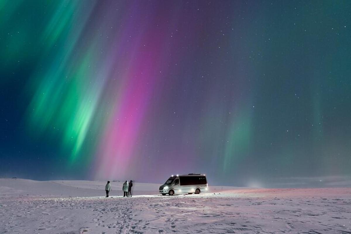 Un grupo de personas de pie junto a una camioneta en la nieve.