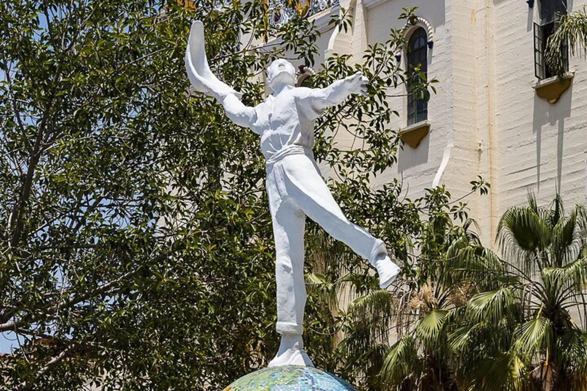 a statue of a man dancing in front of a building