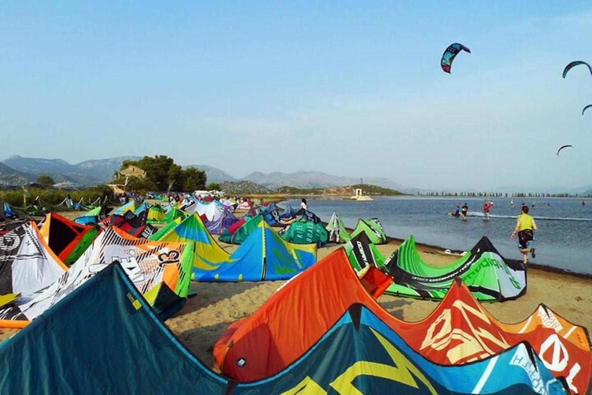 sekumpulan layang-layang di pantai dengan orang menerbangkan layang-layang