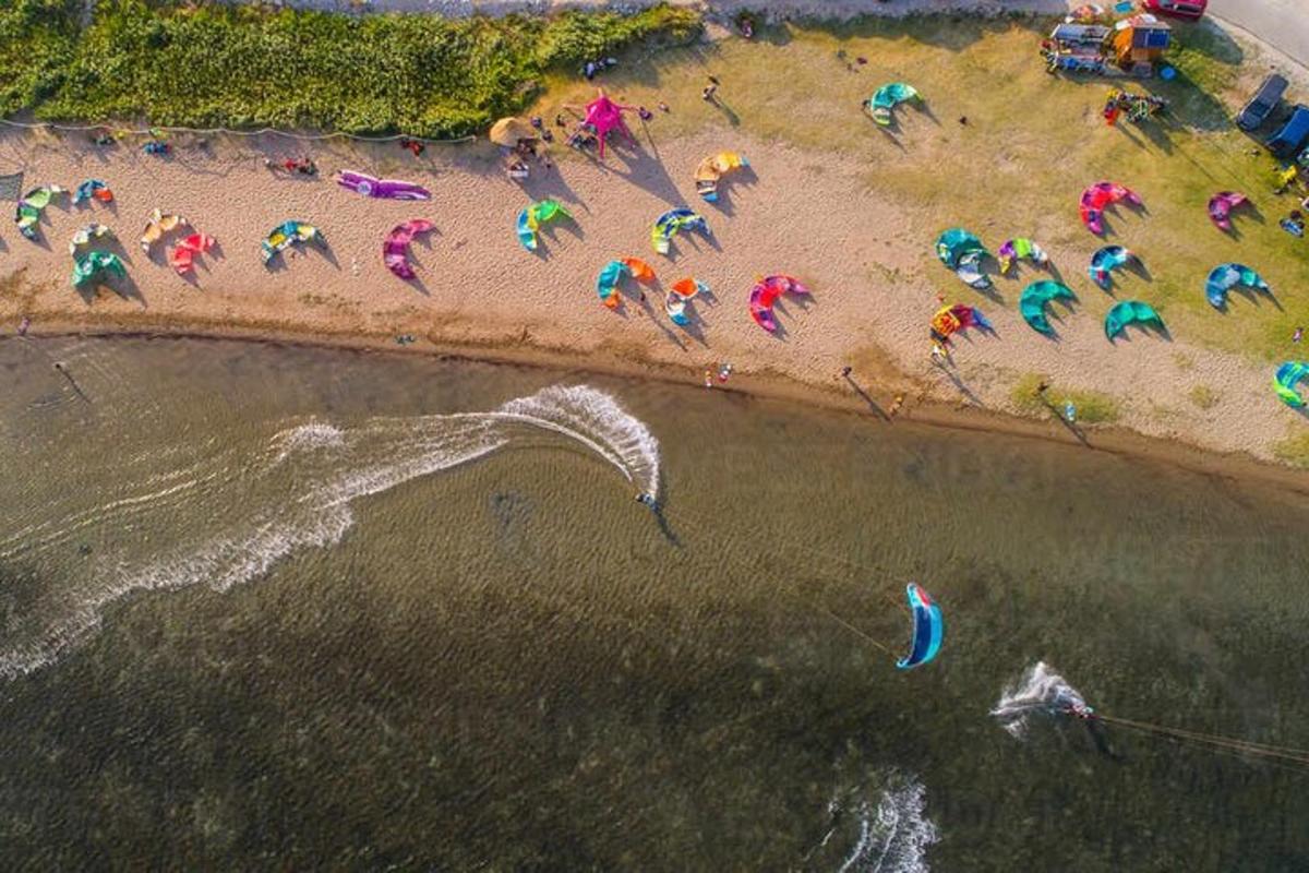 an overhead view of a beach with people with umbrellas