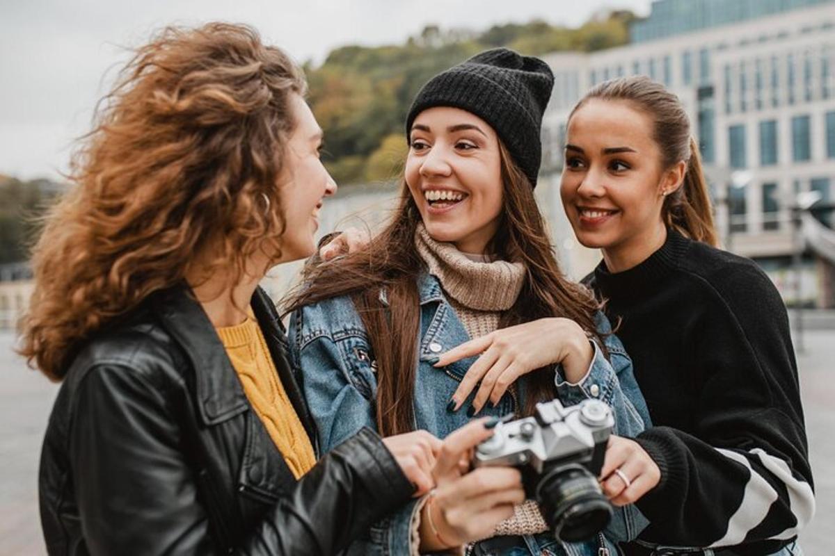 tři ženy stojící vedle sebe a držící fotoaparát
