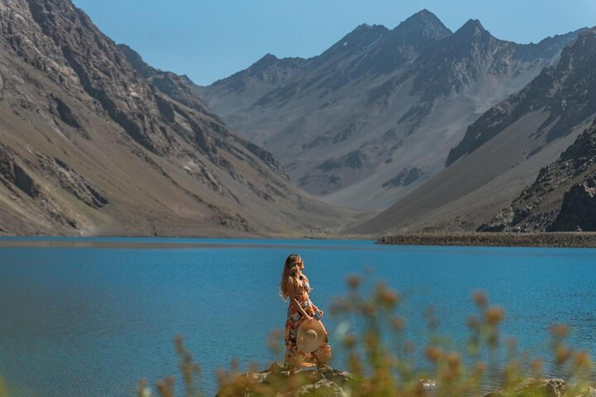 a woman sitting on a rock in front of a lake