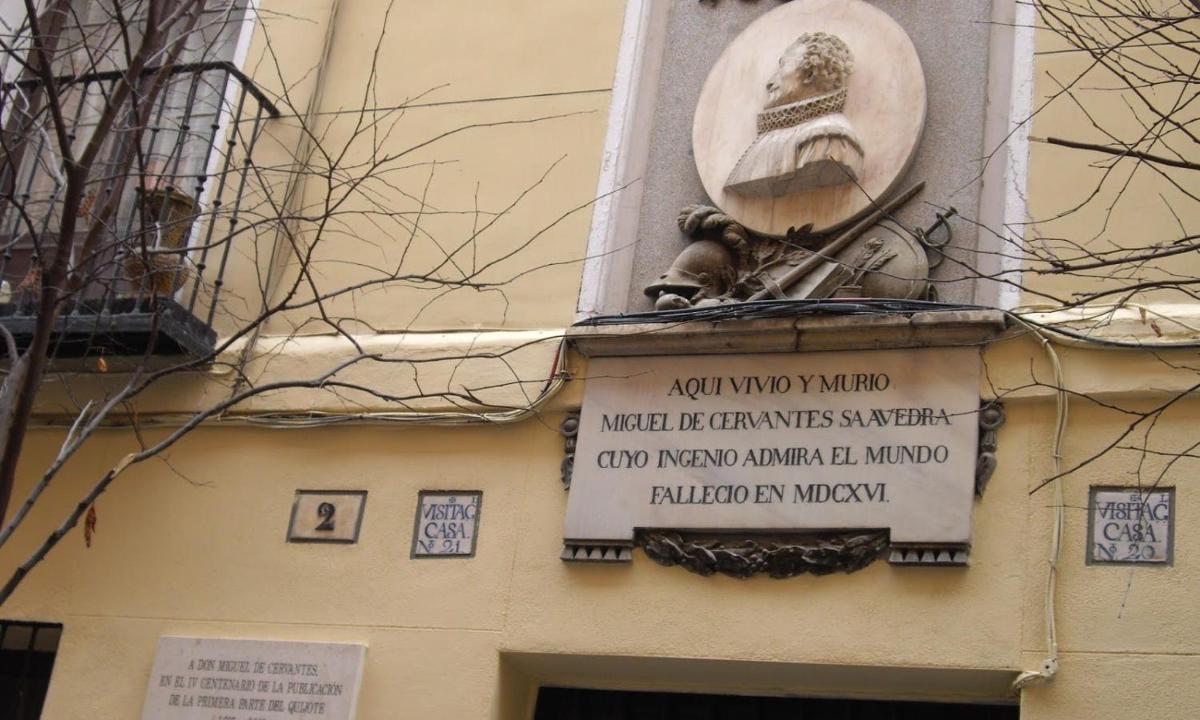 μια πινακίδα στην πλευρά ενός κτιρίου με ένα άγαλμα