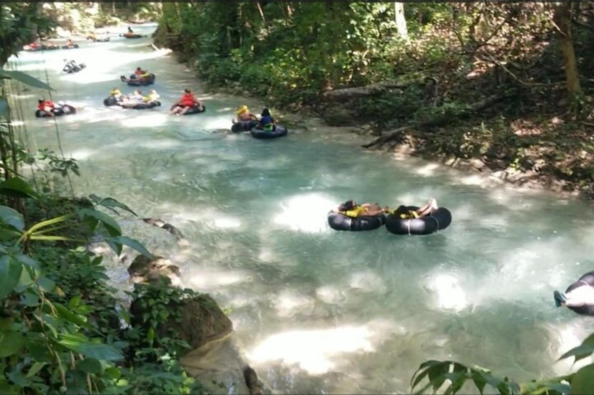 eine Gruppe von Menschen, die auf Schläuchen einen Fluss hinunterfahren