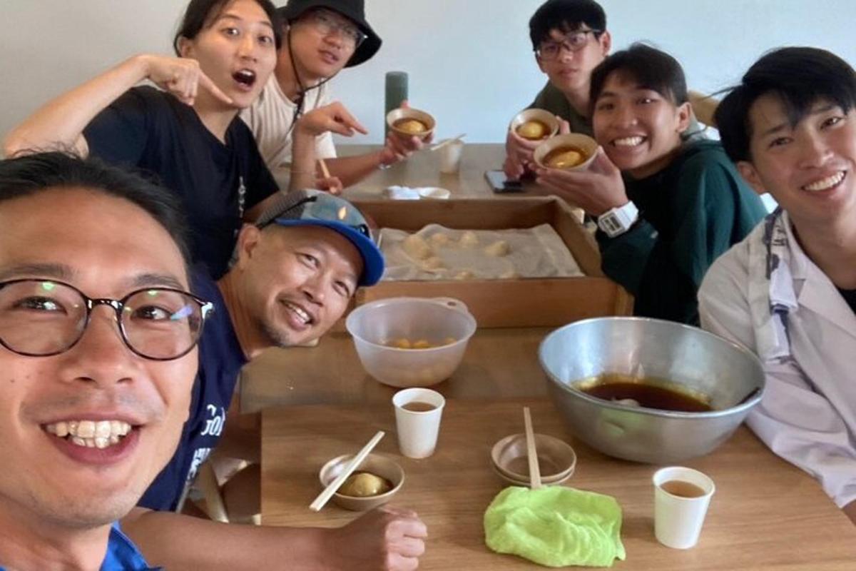 a group of people sitting around a table with donuts