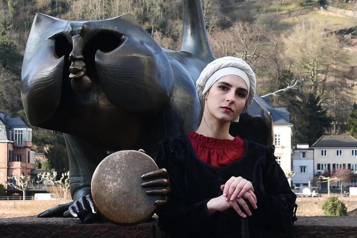 eine Frau steht vor einer Statue
