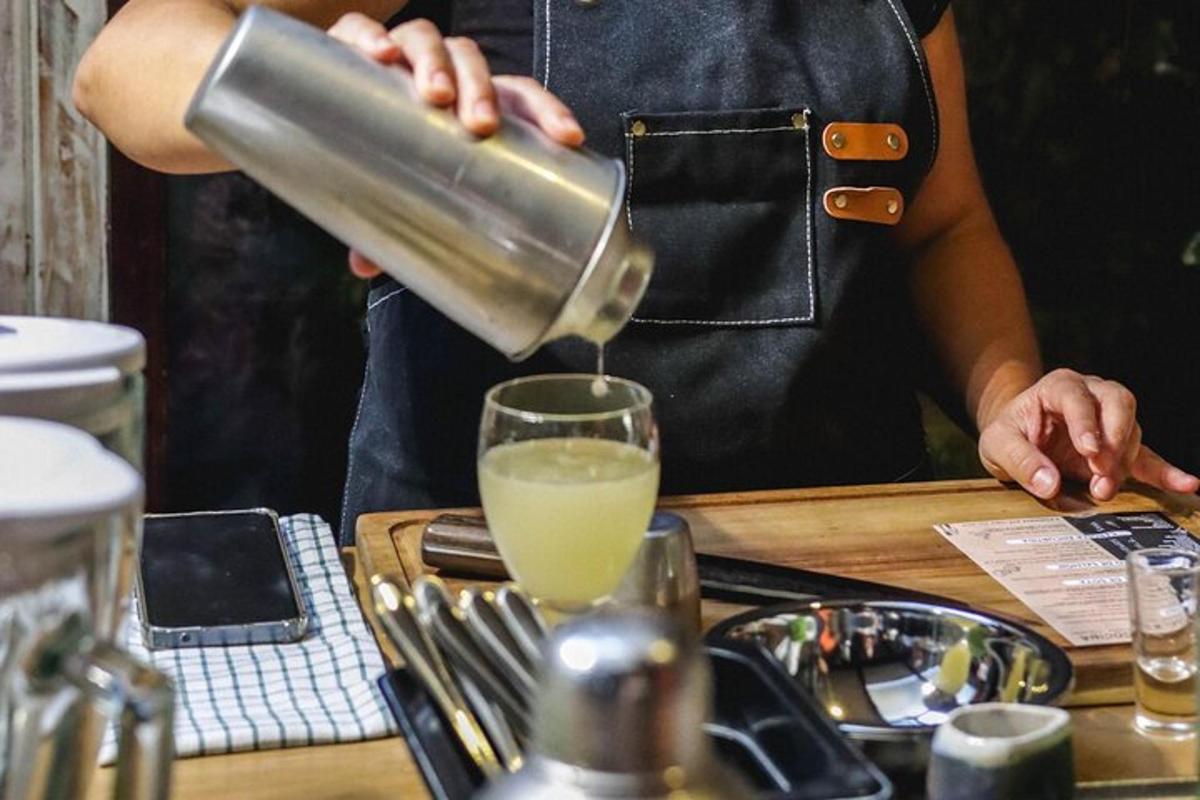 a person pouring a drink into a glass