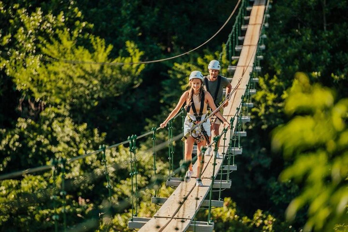 a man and a woman walking across a suspension bridge