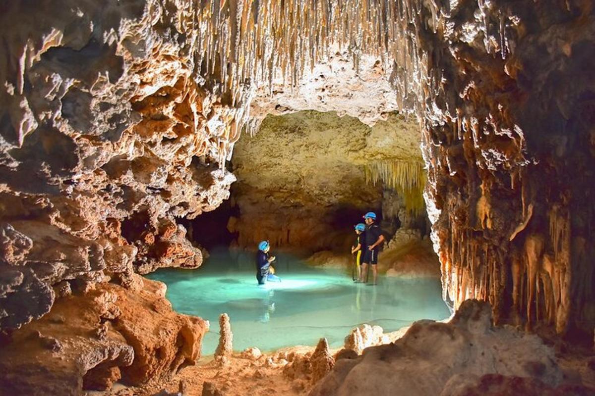 Dos personas de pie en un estanque de agua en una cueva.
