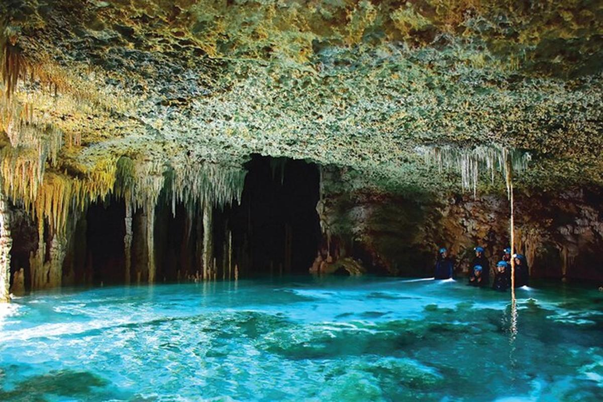 Un grupo de personas de pie en el agua en una cueva.
