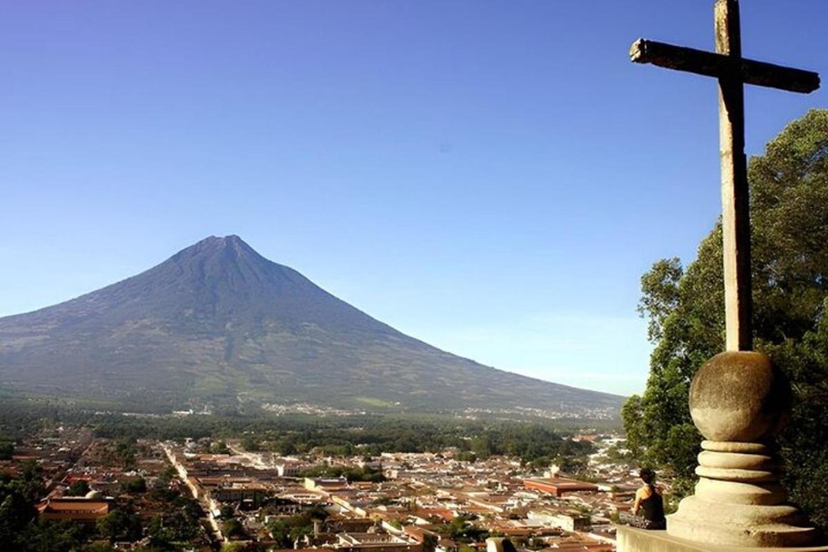 a cross on a hill with a mountain in the background