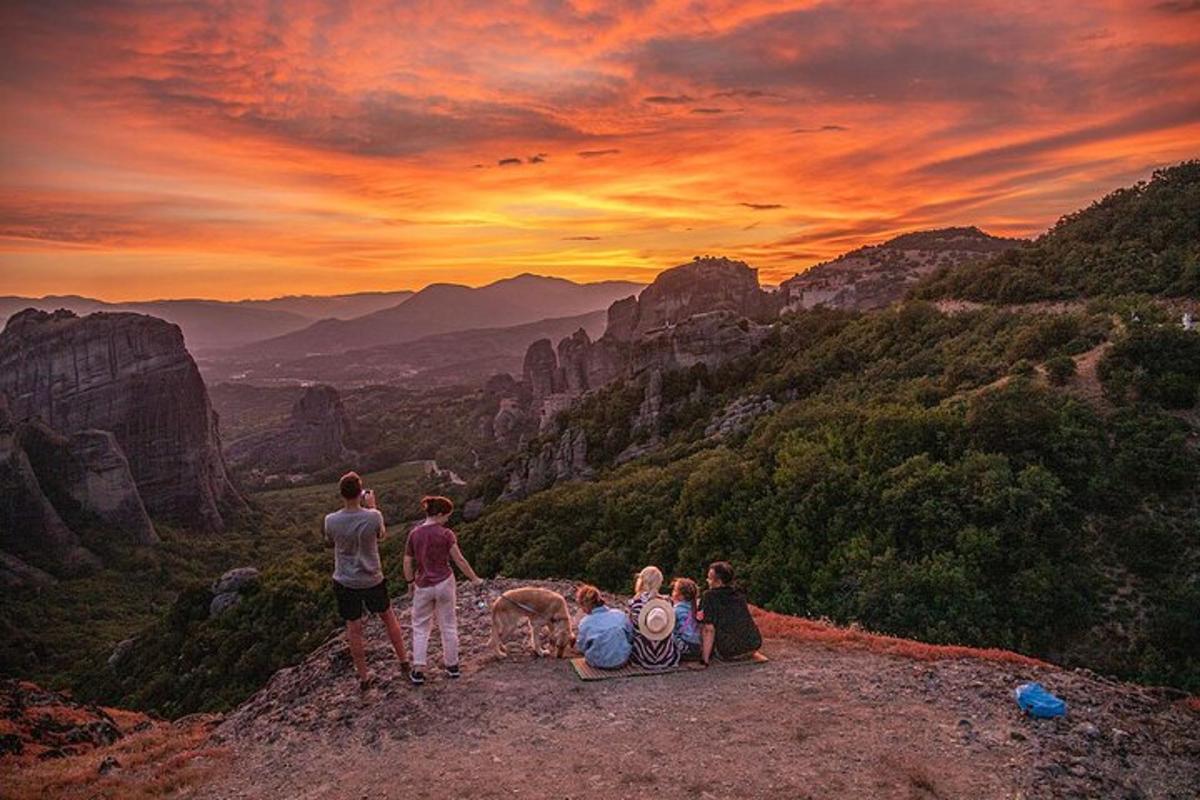 un grup de oameni care stau pe vârful unui munte cu un câine