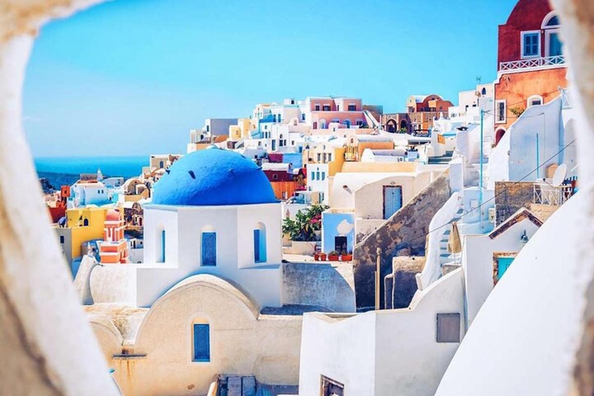 uma vista de uma janela de uma cidade com edifícios brancos