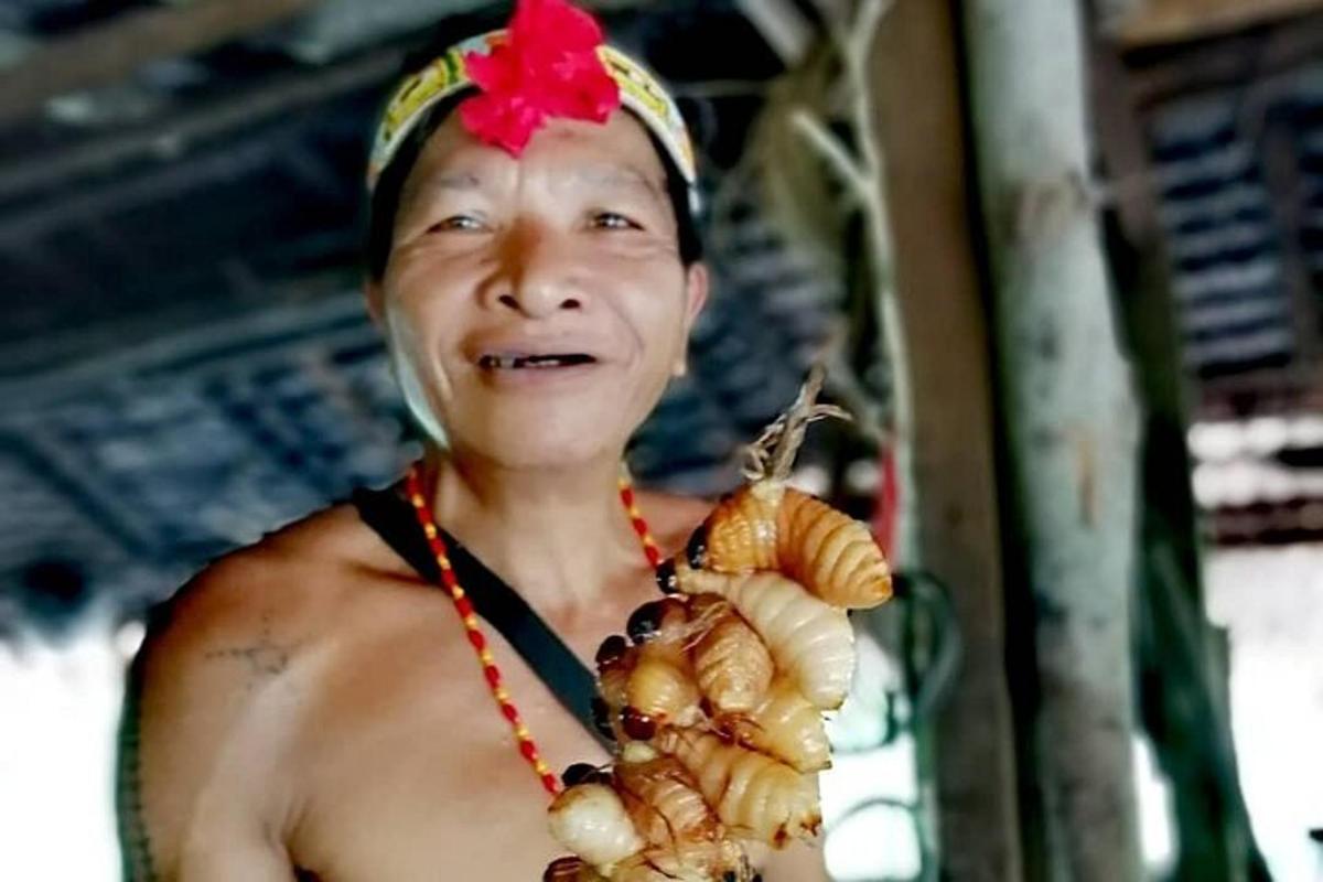 a man wearing a flower on his head with a bunch of food