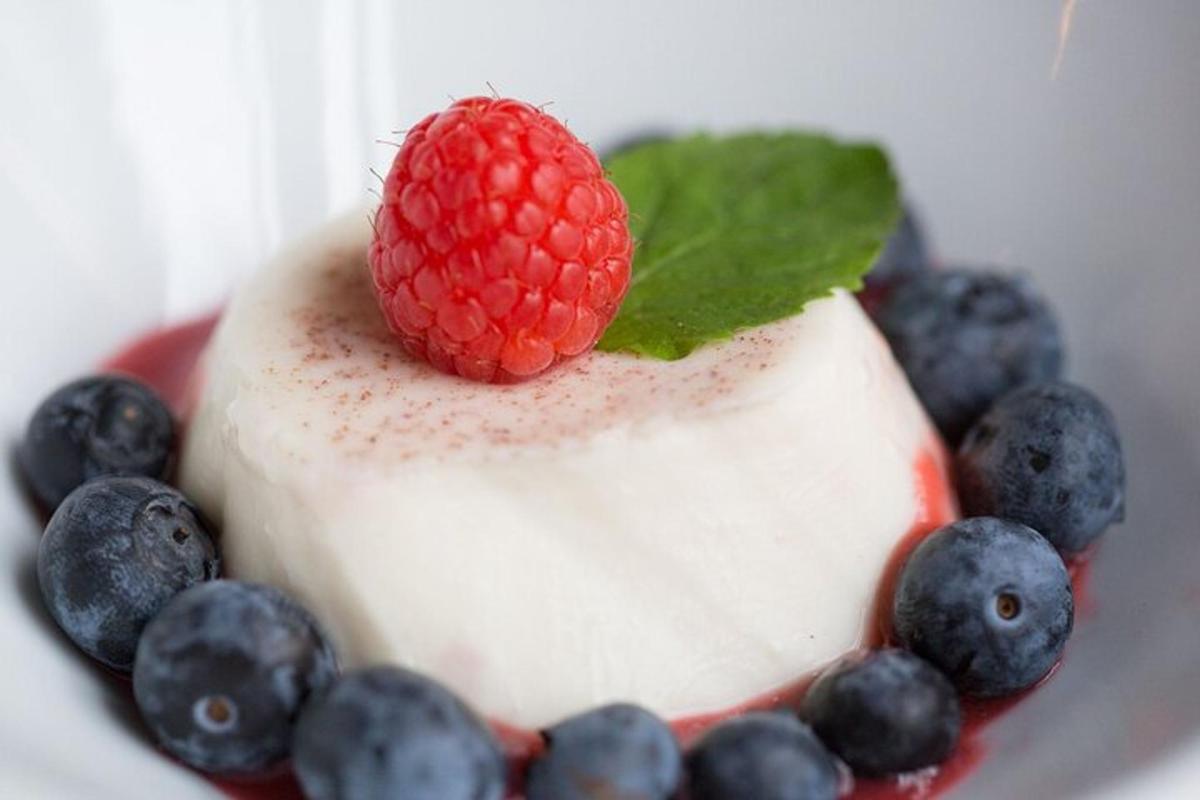 una frambuesa encima de un postre con arándanos y arándanos