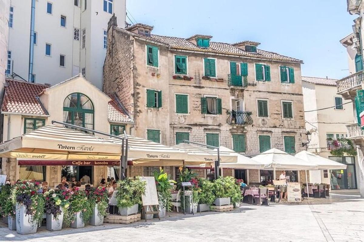 una strada con tavoli e piante di fronte a un edificio