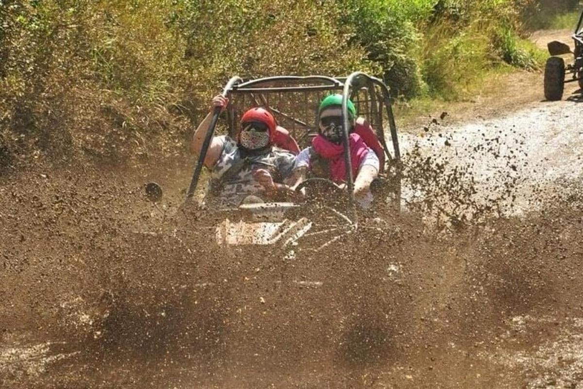 duas pessoas andando de quadriciclo em uma estrada de terra
