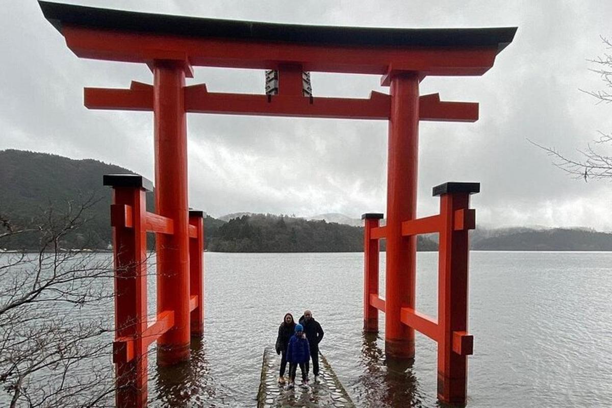 Hópur fólks stendur undir torii-hliði í vatninu