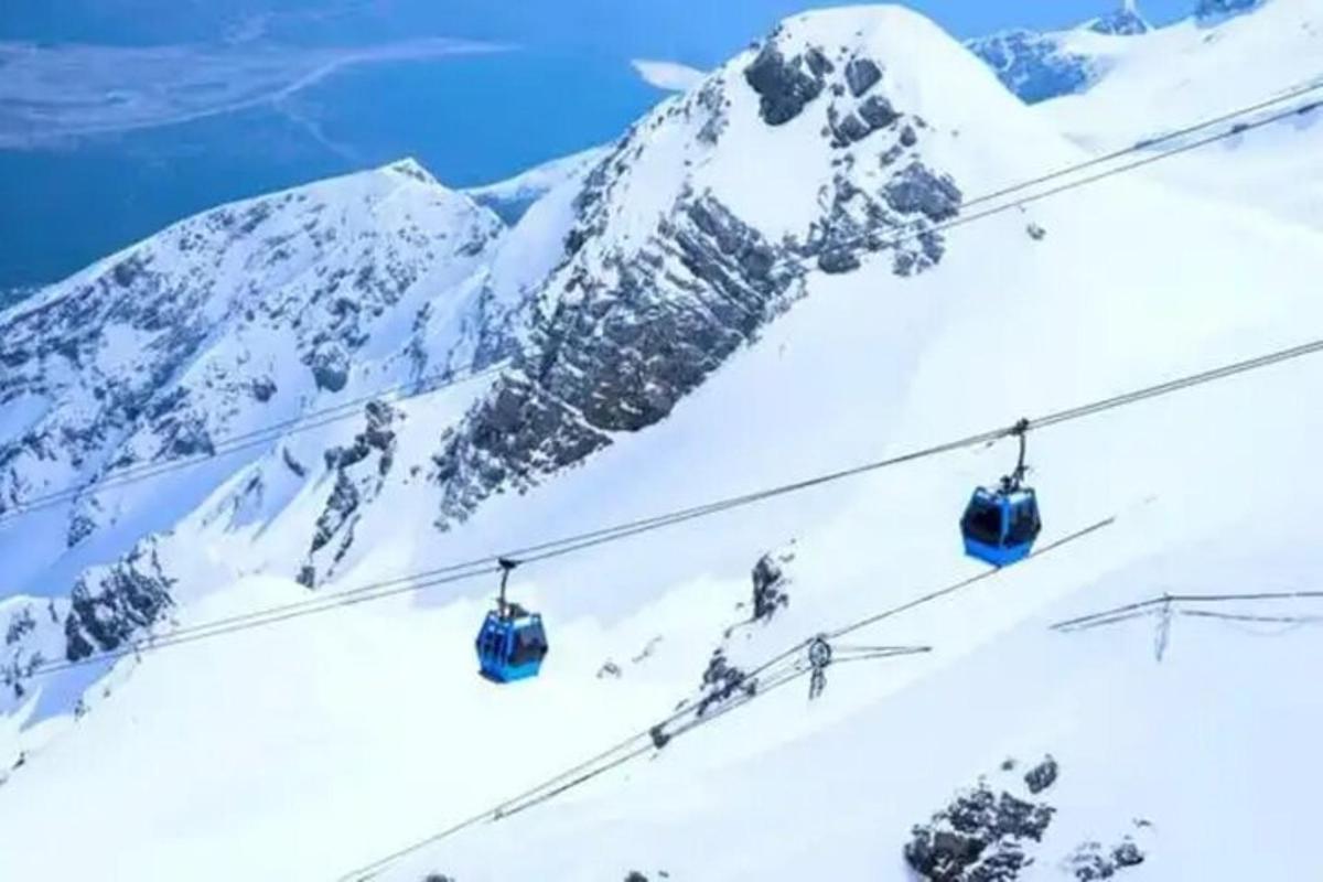 a ski lift in the snow next to a mountain