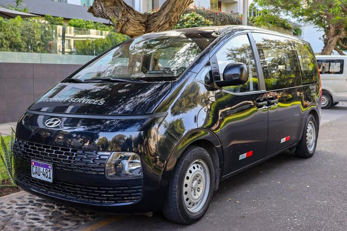 en liten svart varebil parkert på en bygate