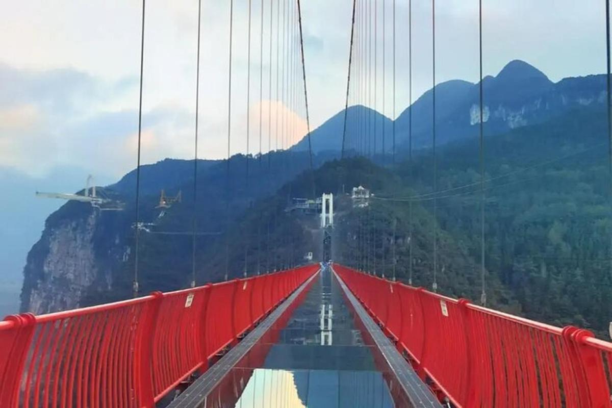un pont vermell amb muntanyes al fons