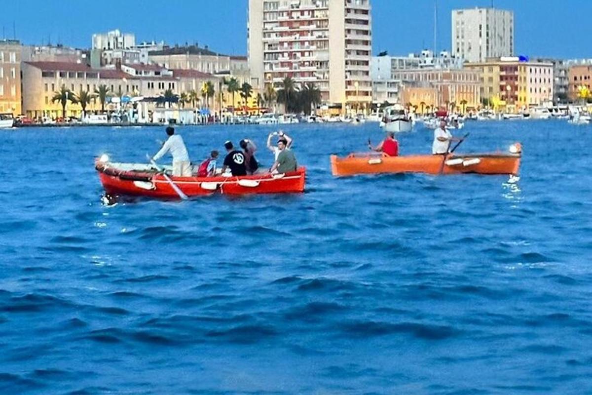 büyük bir su kütlesindeki teknelerdeki bir grup insan