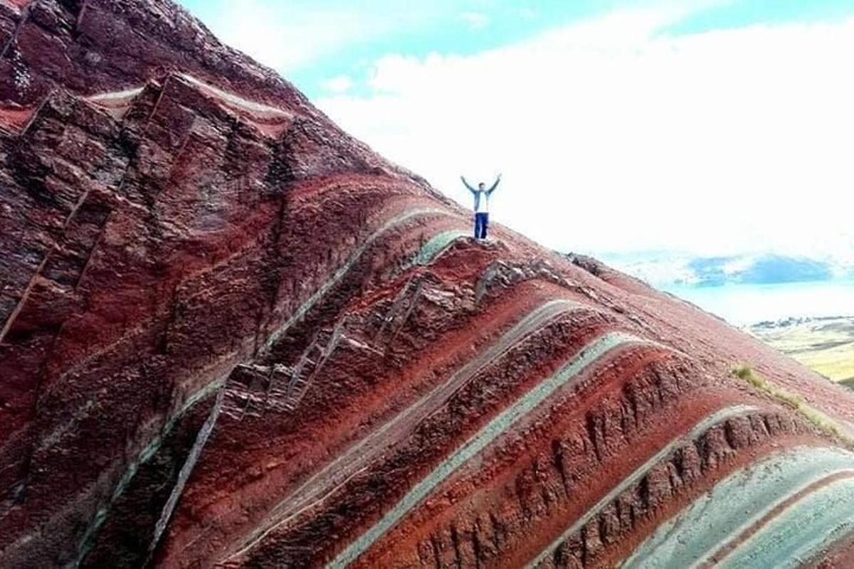 a person standing on the top of a large rock