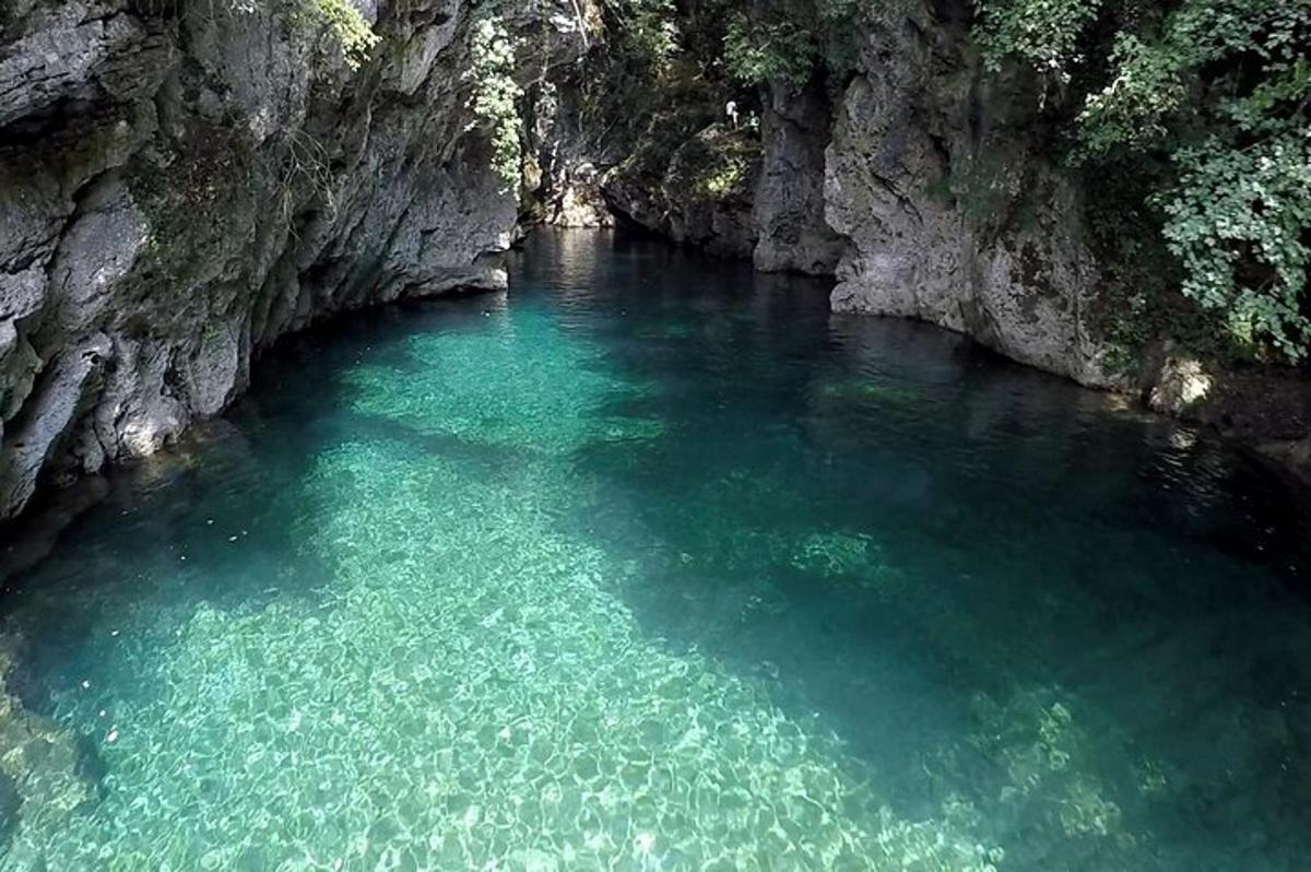 a pool of clear blue water in a cave