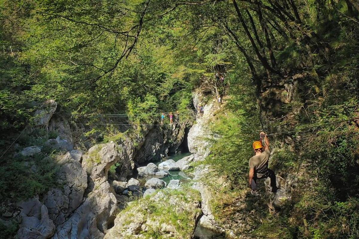 a man standing on the side of a mountain near a river