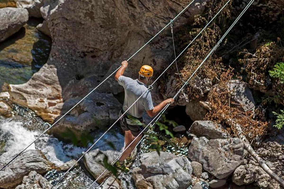 un uomo su un ponte di corda sopra un fiume