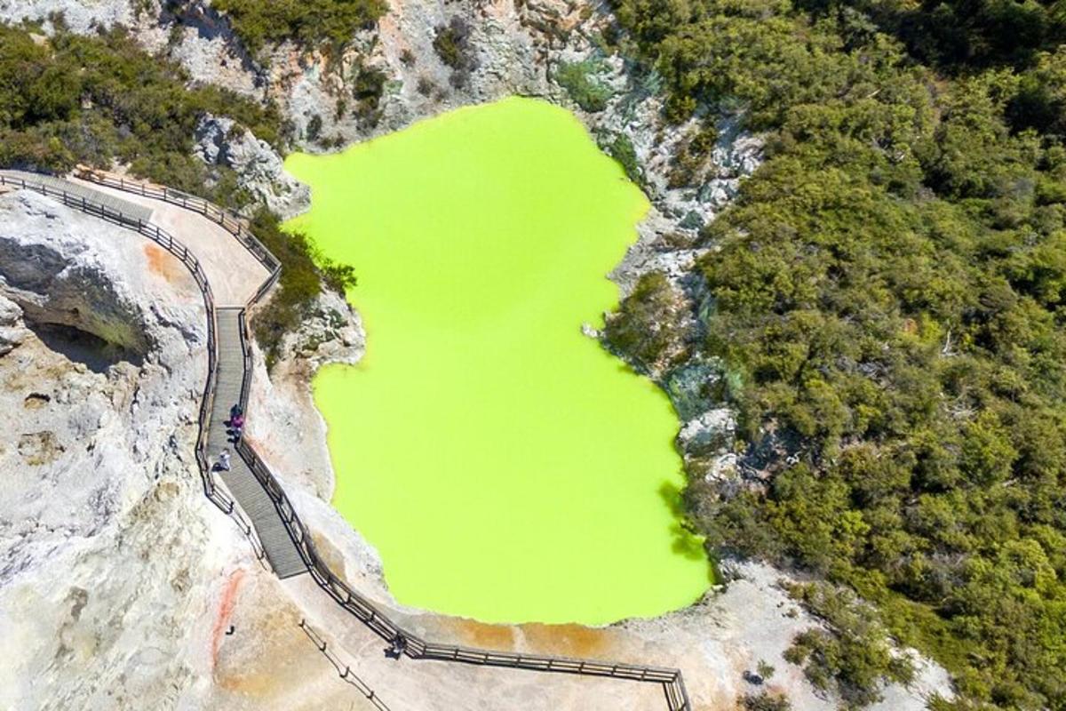 an aerial view of a green lake on the side of a mountain