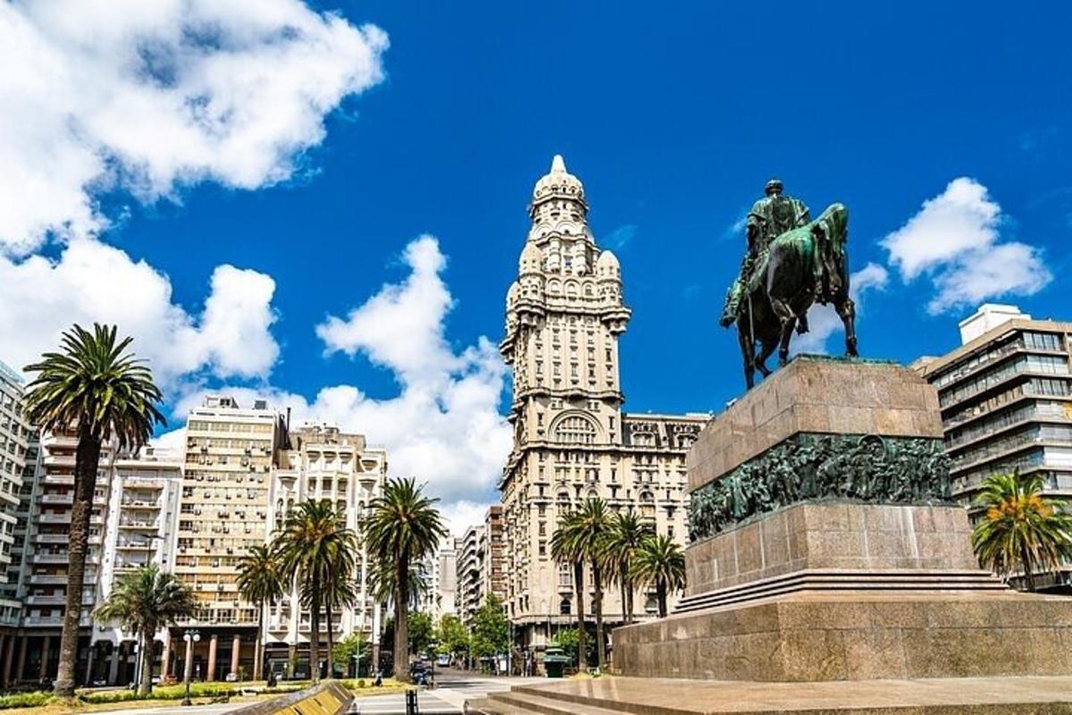 una estatua frente a un edificio con una torre de reloj