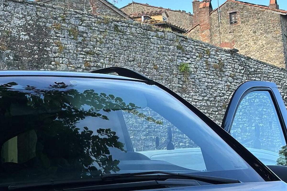 un coche aparcado delante de un muro de piedra