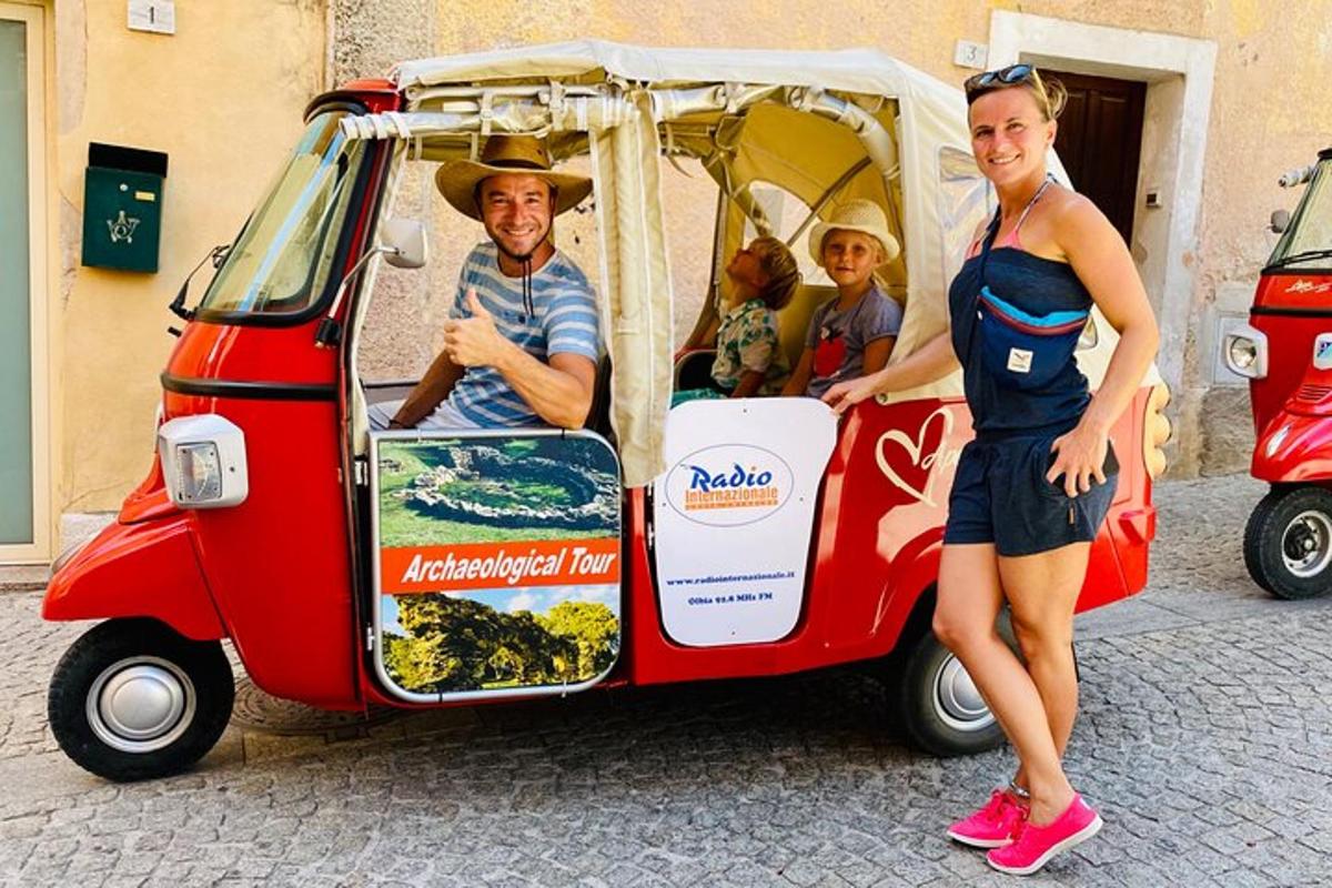 a man and two women standing next to a small car