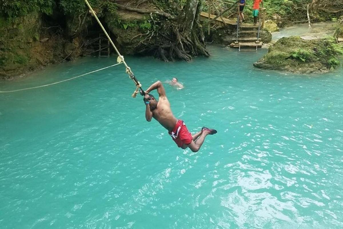 a man hanging from a rope in a river