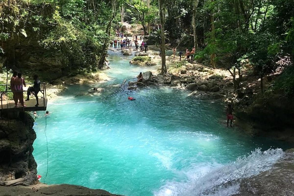 a pool of blue water in a river with people in it