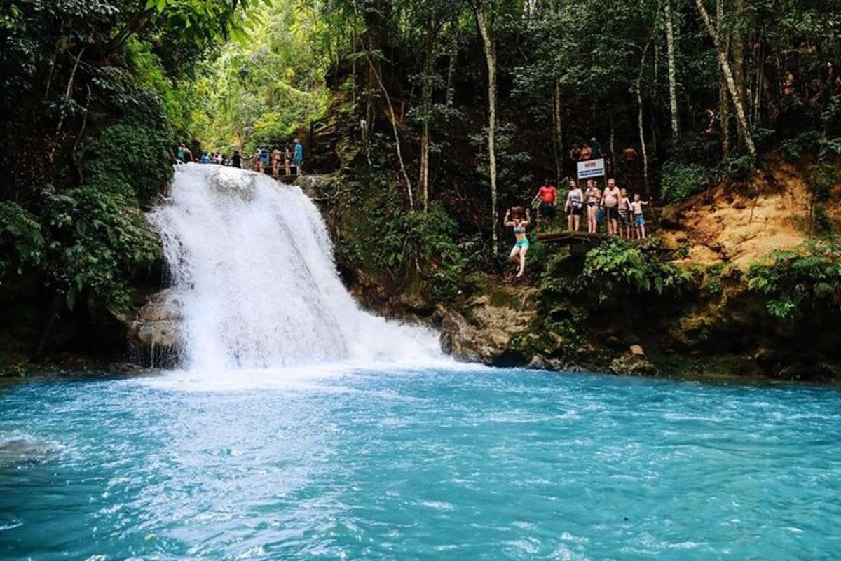 a group of people standing at the top of a waterfall