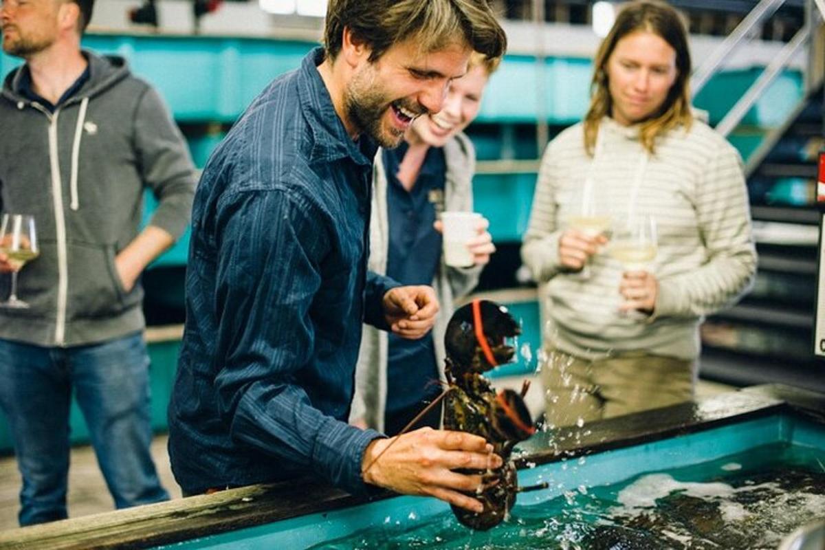 a man holding a lobster in a pool of water