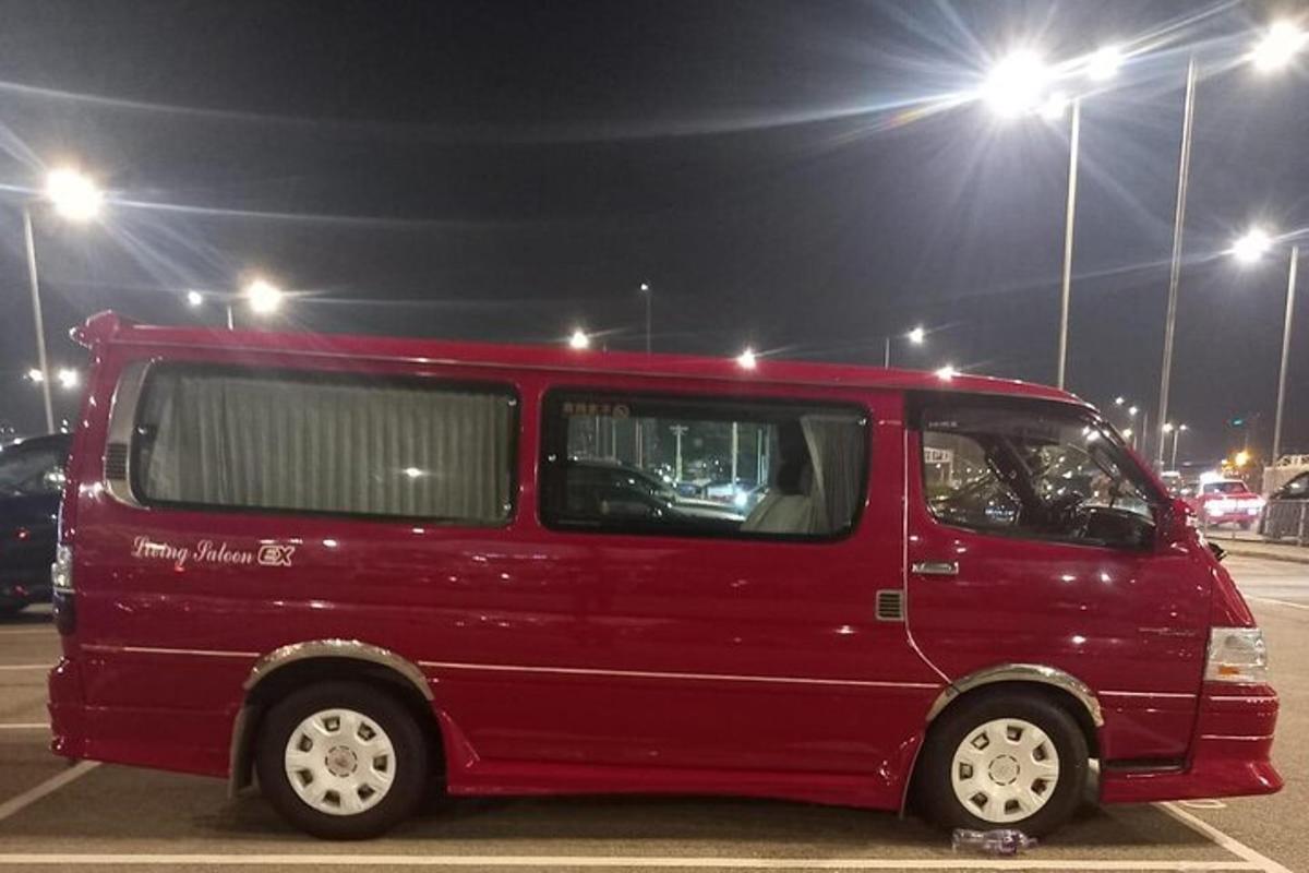a red van parked in a parking lot at night