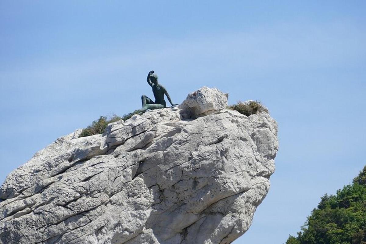 en mann som sitter på toppen av en stein