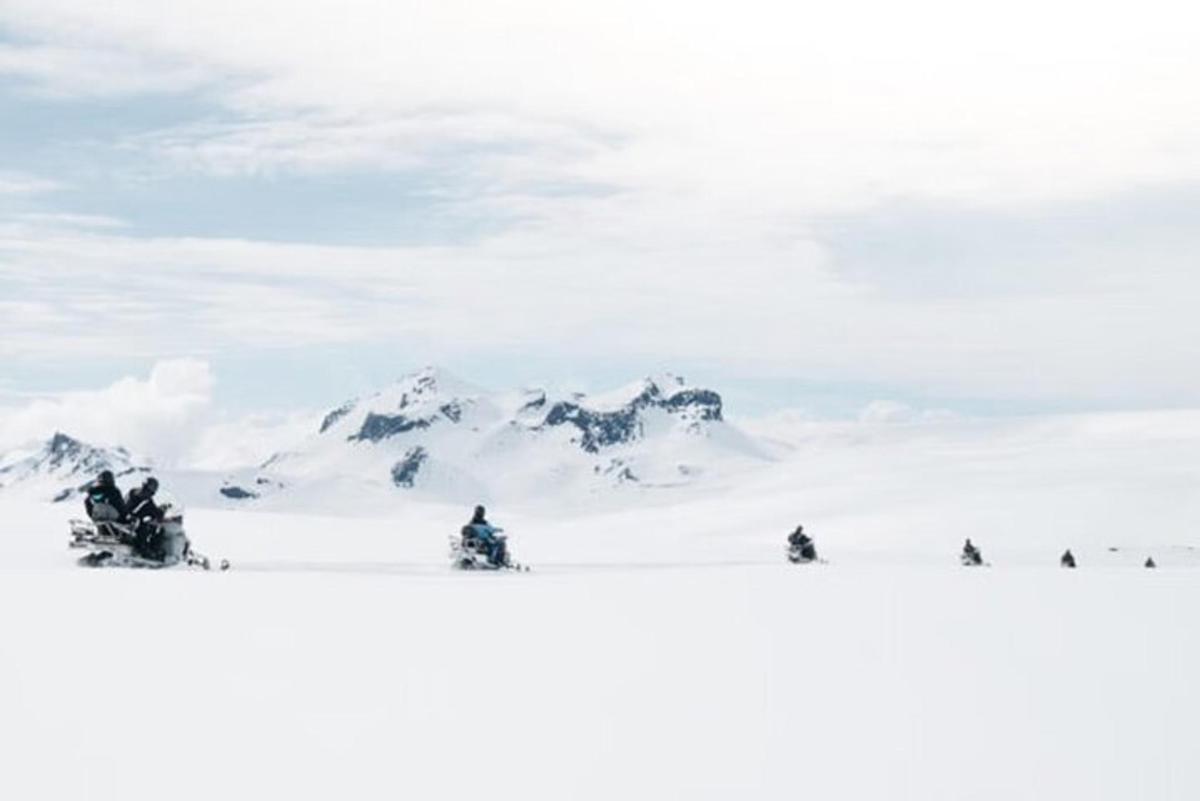 en gruppe mennesker, der står på ski på et snedækket bjerg