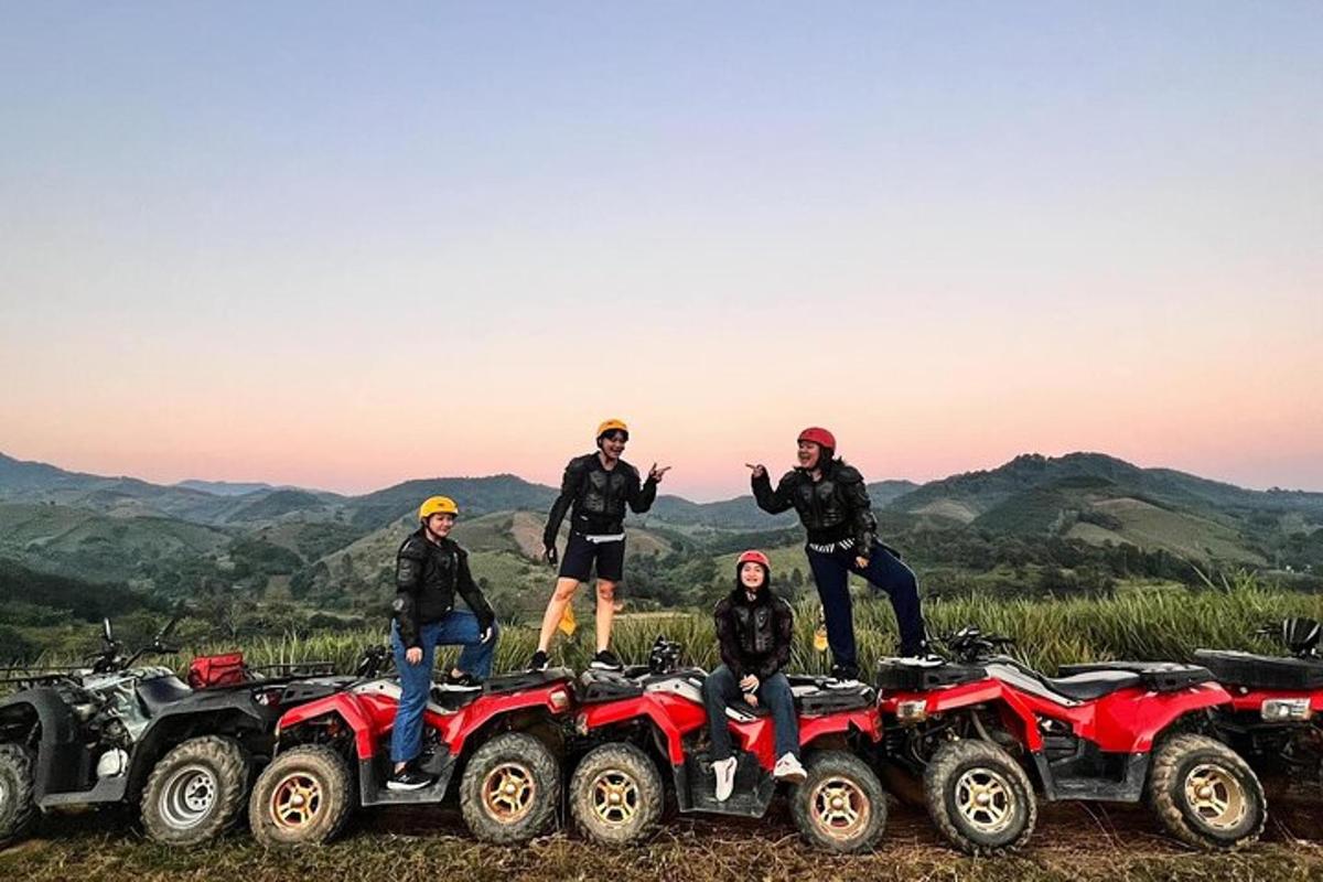 a group of people standing on four atvs