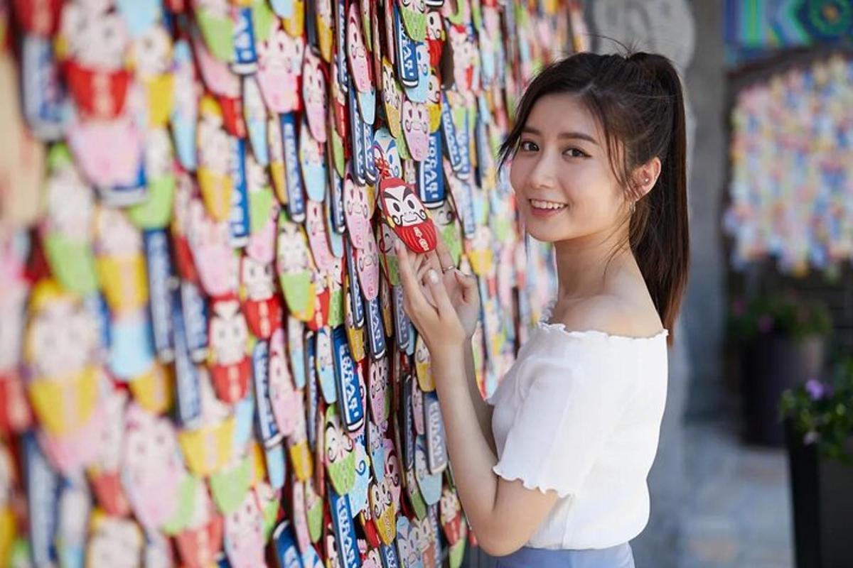 a young woman standing next to a wall of soda cans