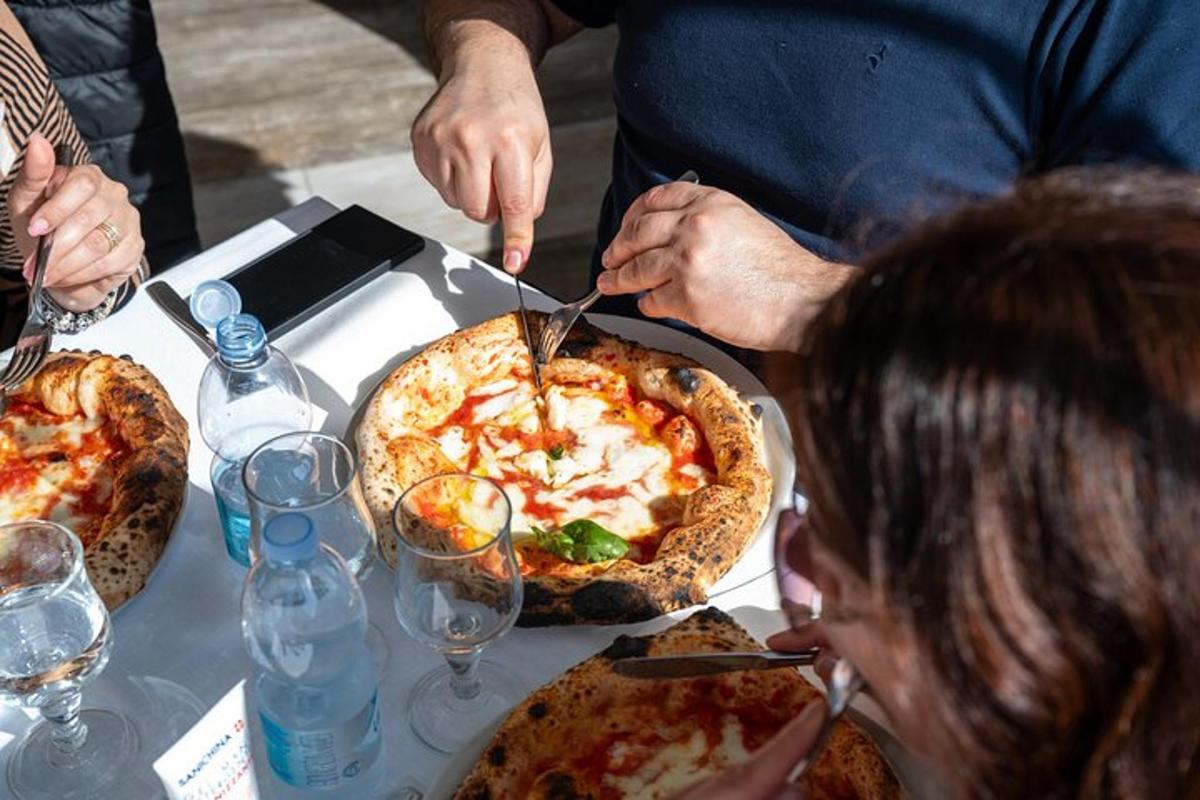 una persona che taglia una pizza su un tavolo