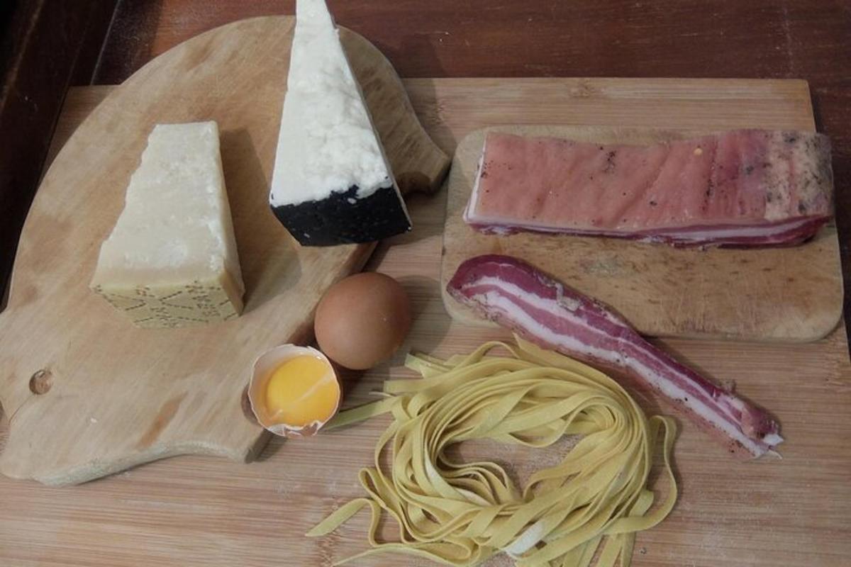 a wooden cutting board with cheese pasta and meats and eggs