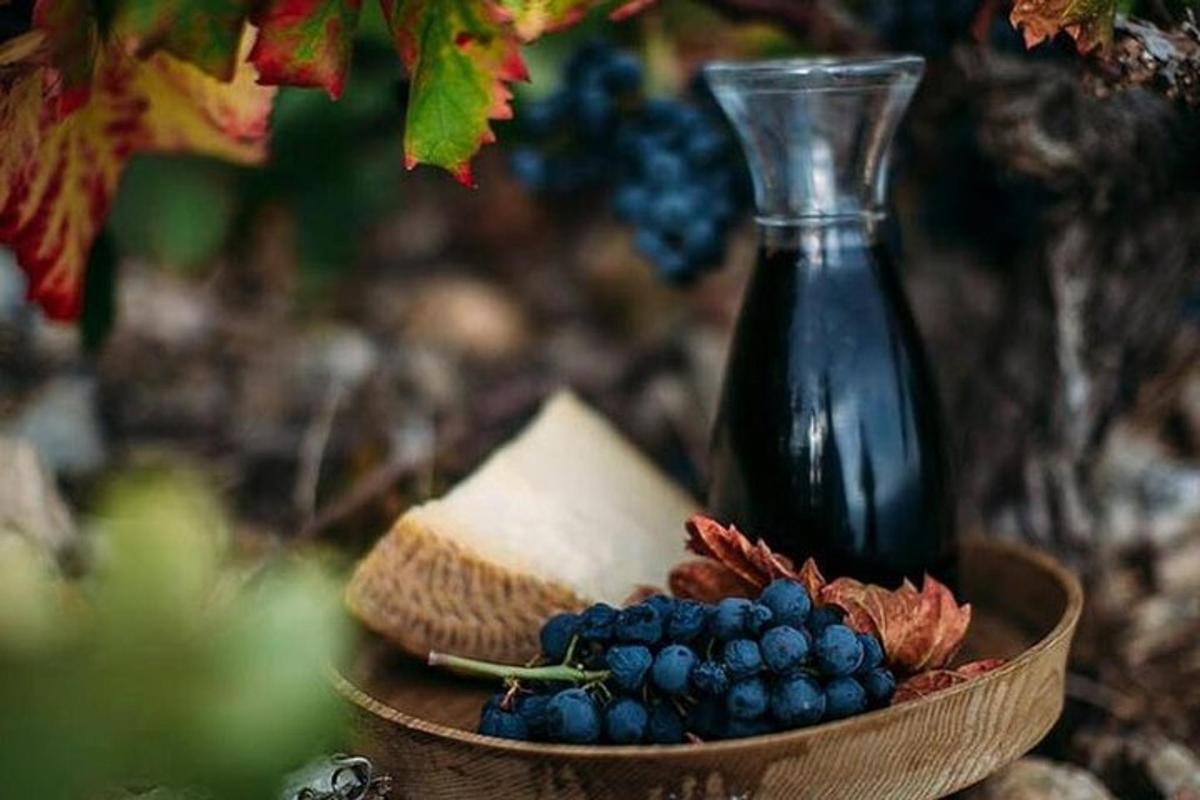 a bottle of wine and a bowl of cheese and grapes