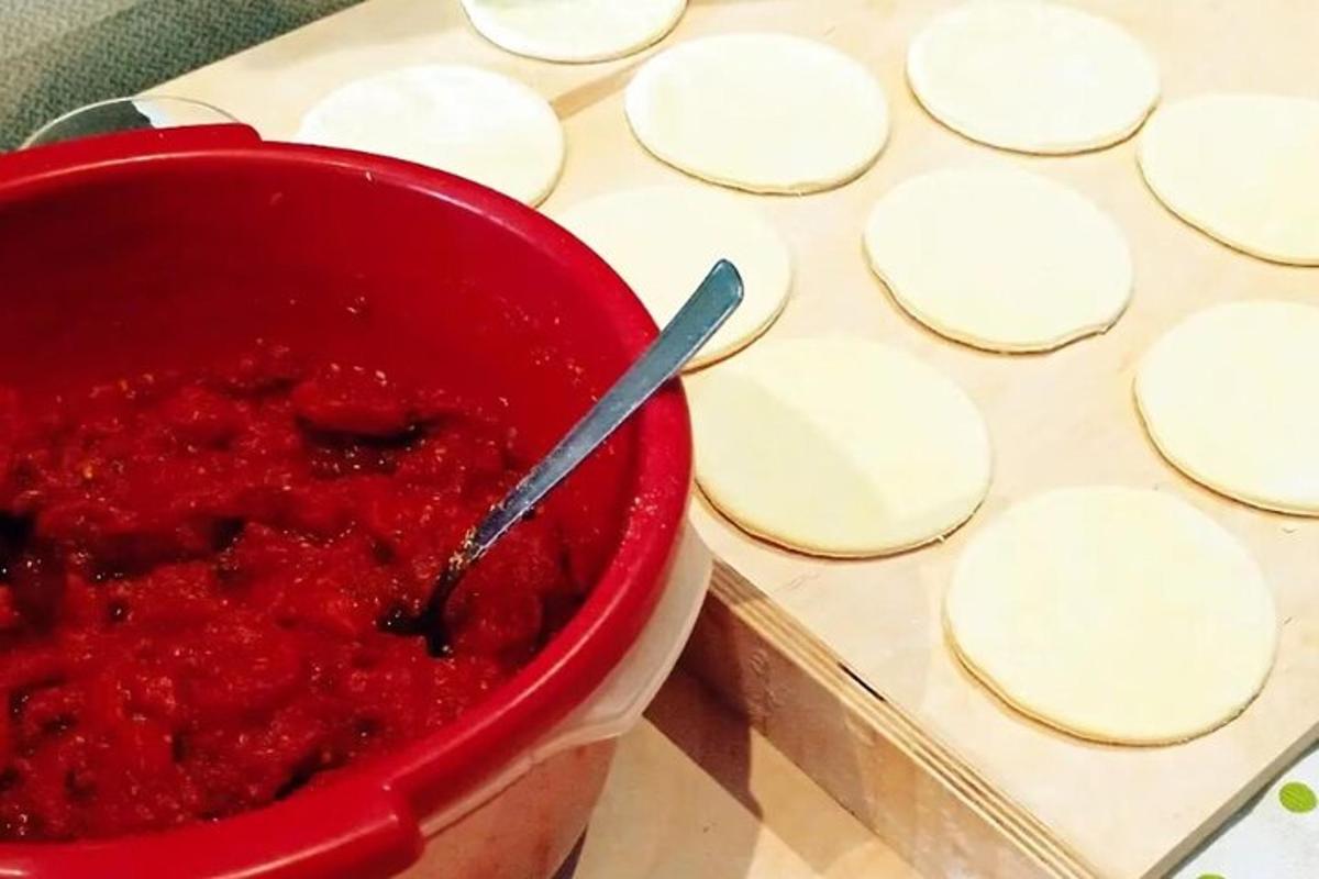 một bát nước sốt đỏ bên cạnh một đống thức ăn