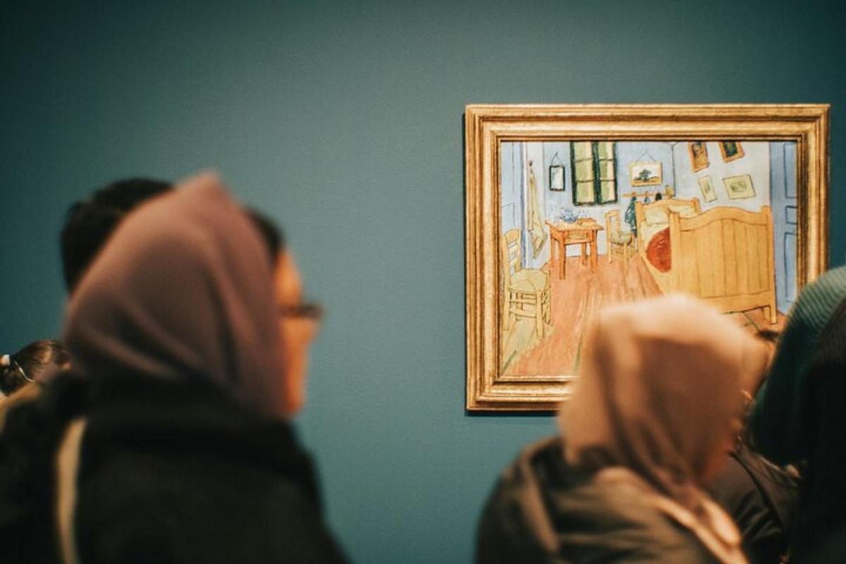 a group of people looking at a painting on a wall