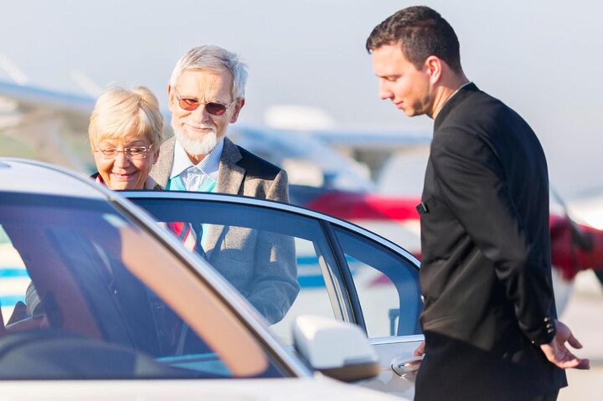 dva muži a starší žena si prohlížejí auto